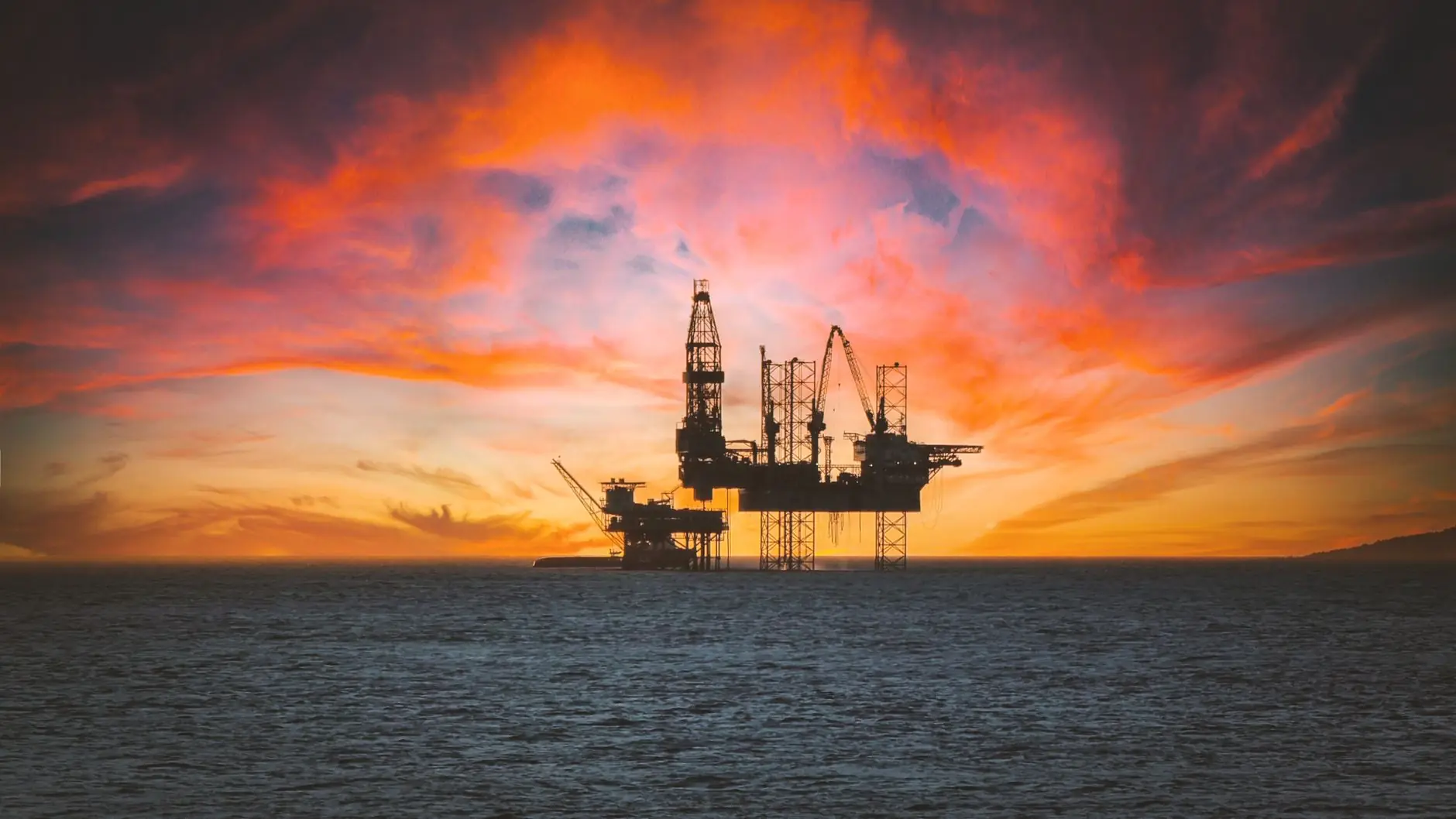 Offshore rig silhouetted at sunset