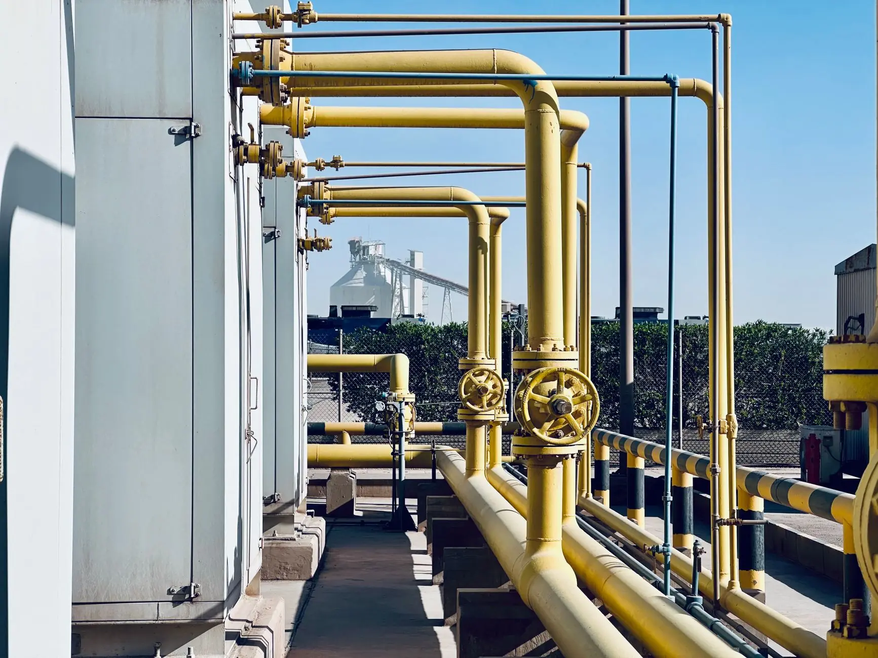 Yellow process pipework and valves at an industrial site
